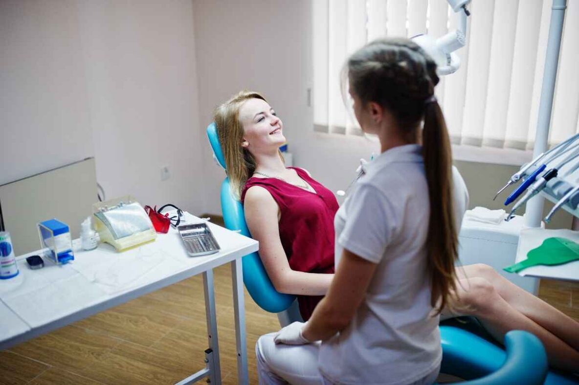 Patient relaxing in a dental chair while discussing dental implant treatment with a dentist