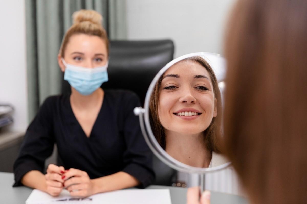 Patient reviewing her smile during a veneers consultation for cosmetic dental improvements